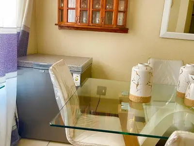 a glass table in a kitchen next to a refrigerator at Inocova Fly in Kempton Park
