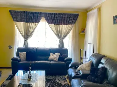 a living room with a blue couch and a glass table at Inocova Fly in Kempton Park