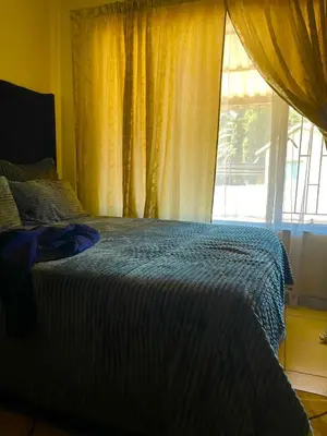 a bedroom with a bed and a large window at Inocova Fly in Kempton Park
