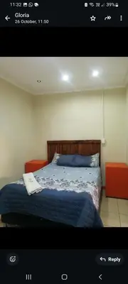 a bedroom with a bed with a blue comforter at Limelight in Polokwane