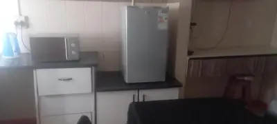 a small kitchen with a white refrigerator in a room at Limelight in Polokwane