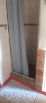 a bathroom with a shower with a curtain and a floor at Limelight in Polokwane