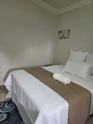 a bedroom with a large bed with white sheets at The Cypress Guesthouse in Pretoria