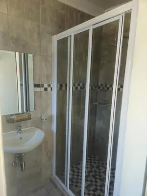a bathroom with a shower and a sink at The Cypress Guesthouse in Pretoria