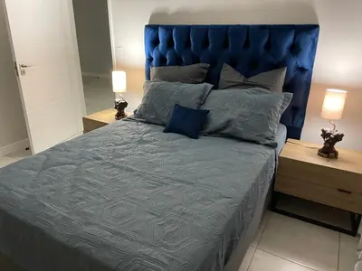 a blue bed with a blue headboard in a bedroom at The Blyde Apartment in Pretoria