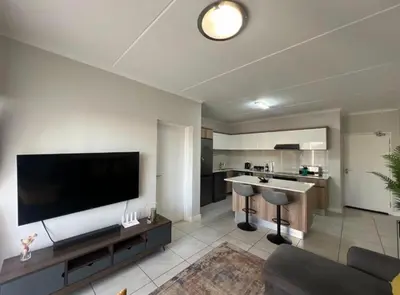 a large living room with a large flat screen tv at The Blyde Apartment in Pretoria