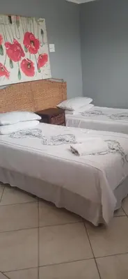 two beds in a room with white sheets and pillows at 16 Besembos contractors accommodation in Witbank