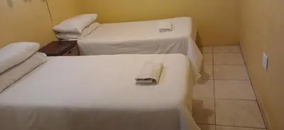 two beds in a room with a towel on the bed at 16 Besembos contractors accommodation in Witbank