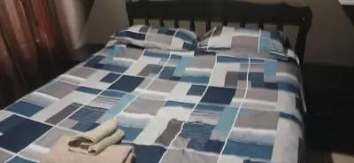 a blue and white bed with two pillows and towels at 16 Besembos contractors accommodation in Witbank
