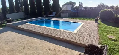 a small swimming pool in a yard with a brick pathway at 16 Besembos contractors accommodation in Witbank