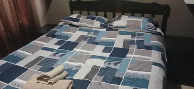 a bed with a blue and white comforter and pillows at 16 Besembos contractors accommodation in Witbank