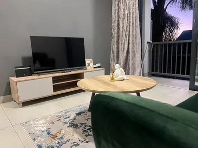 a living room with a tv and a coffee table at Modern Apartment in Centurion in Centurion
