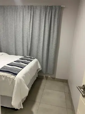 a bedroom with a bed and a window with curtains at Modern Apartment in Centurion in Centurion
