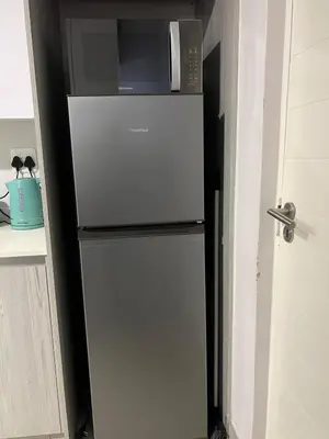 a small refrigerator with a microwave on top of it at Modern Apartment in Centurion in Centurion