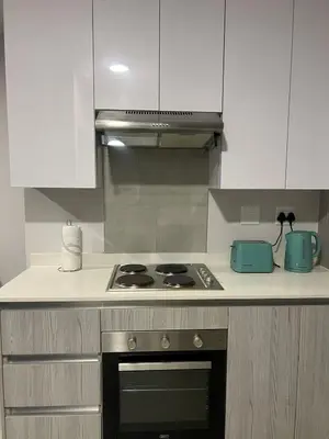 a kitchen with a stove and white cabinets at Modern Apartment in Centurion in Centurion