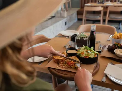 a group of people sitting at a table eating food at ANEW Resort Hazyview Kruger Park in Hazyview