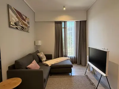 a living room with a couch and a flat screen tv at 136 Trilogy in Pretoria