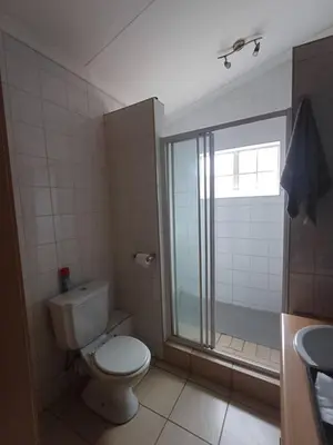 a bathroom with a toilet and a shower and a sink at Bufflesdrift Bush and Birding in Pretoria