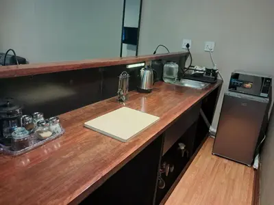 a kitchen with a wooden counter top with a refrigerator at The Nugget Guest Lodge in Kempton Park