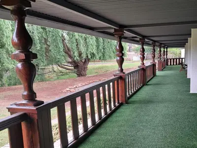a porch with wooden railings and a green floor at The Nugget Guest Lodge in Kempton Park