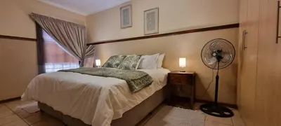 a bedroom with a bed with a fan and a window at Bet Baruch Accommodation 1 in Polokwane