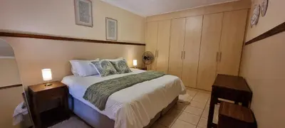 a bedroom with a large bed with two lamps on it at Bet Baruch Accommodation 1 in Polokwane