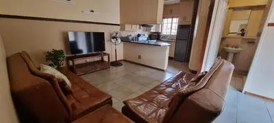 a living room with two brown leather couches and a kitchen at Bet Baruch Accommodation 1 in Polokwane