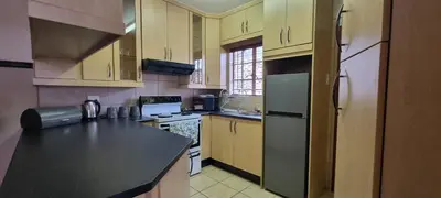 a kitchen with wooden cabinets and a black counter top at Bet Baruch Accommodation 1 in Polokwane