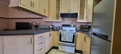 a kitchen with white cabinets and a stainless steel refrigerator at Bet Baruch Accommodation 1 in Polokwane