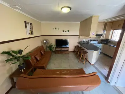 a living room with a couch and a kitchen at Bet Baruch Accommodation 1 in Polokwane