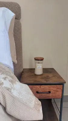 a nightstand with a candle on top of a bed at La Boheme in Pretoria