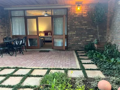 a patio with a table and chairs and a brick wall at B&B on the Sabie in Sabie
