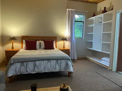 a bedroom with a bed and two lamps and a window at B&B on the Sabie in Sabie