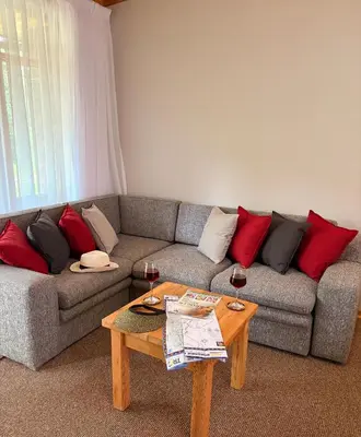 a living room with a couch and two glasses of wine at B&B on the Sabie in Sabie