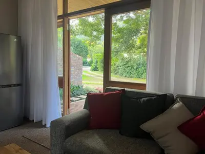 a living room with a couch and a large window at B&B on the Sabie in Sabie