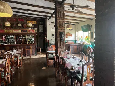 a restaurant with tables and chairs and a bar at B&B on the Sabie in Sabie