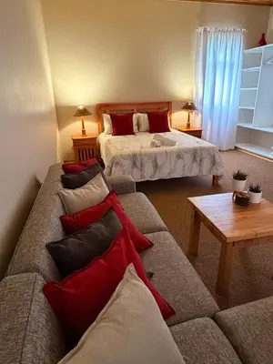 a living room with two beds and a couch with pillows at B&B on the Sabie in Sabie