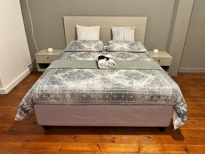 a bed with a stuffed animal laying on top of it at 326onMackenzieSt in Pretoria