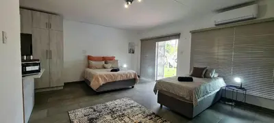 a bedroom with a bed and a couch and a window at Tenuta Overnight Suite in Polokwane