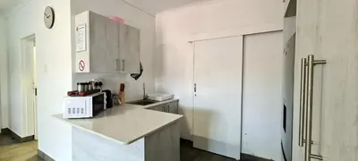 a kitchen with white cabinets and a counter with a microwave at Tenuta Overnight Suite in Polokwane