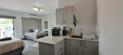 a kitchen with a sink and a room with a bed at Tenuta Overnight Suite in Polokwane
