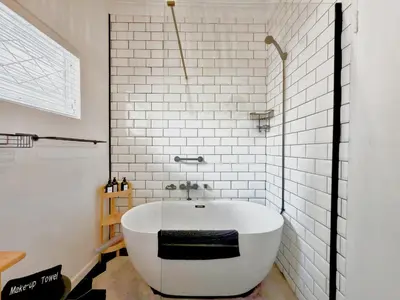 a bath tub in a bathroom with white tiles at Maroelana Home in Pretoria