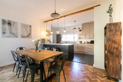 a kitchen and dining room with a wooden table and chairs at Maroelana Home in Pretoria