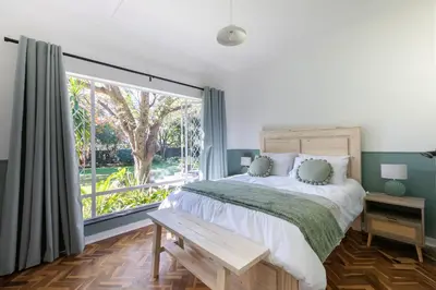 a bedroom with a bed and a large window at Maroelana Home in Pretoria