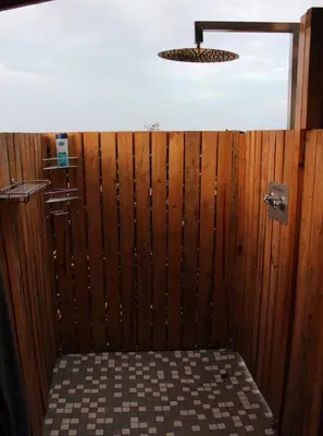 a bathroom with a wooden fence and a light at Tierpoort Barn in Mountain in Tierpoort