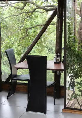 a table and chairs in front of a large window at Tierpoort Barn in Mountain in Tierpoort