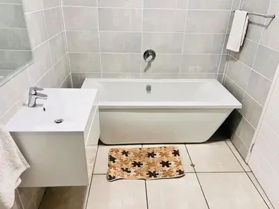 a bathroom with a white tub and a sink at The Blyde Crystal Lagoon in Pretoria