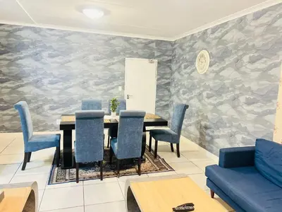 a dining room with a table and blue chairs at The Blyde Crystal Lagoon in Pretoria