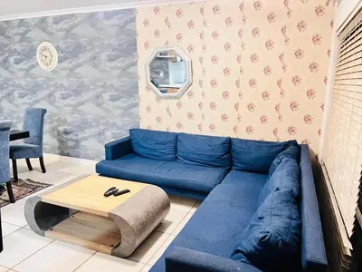 a living room with a blue couch and a table at The Blyde Crystal Lagoon in Pretoria