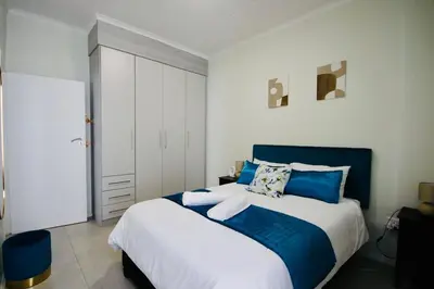 a bedroom with a large bed with blue and white at PC Luxe Stays exquisite apartments in Erand